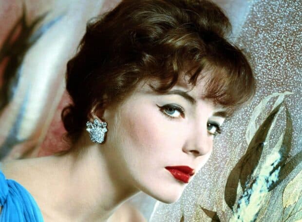 A close up of Joan Collins wearing a blue dress and sparkling earrings, looking sideways with red lipstick, HD Desktop Wallpaper