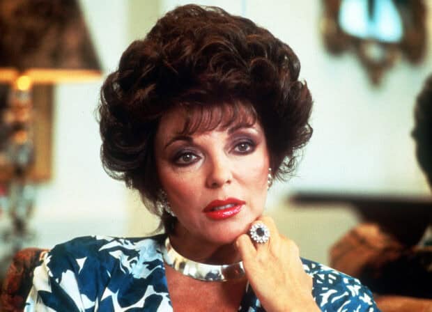 Joan Collins poses with a thoughtful expression wearing a blue patterned outfit, 2K Desktop Wallpaper