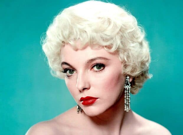 Joan Collins wallpapers show a close up of her face with green eyes and curled blonde hair, HD Desktop Wallpaper