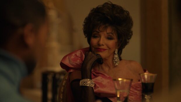 Joan Collins Wallpapers shows a woman in a pink dress with black gloves and intricate jewelry sitting at a table, HD Desktop Wallpaper