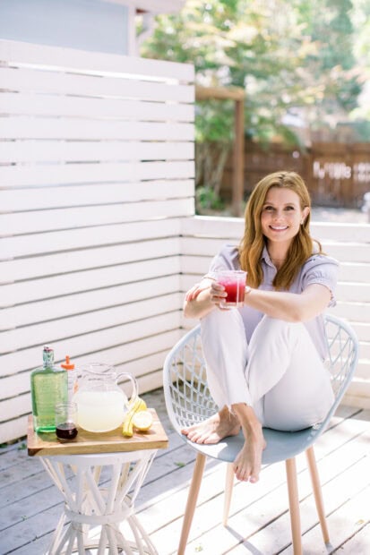 Joanna Garcia Swisher is sitting on a chair holding a refreshing drink outdoors on a sunny day, HD Mobile Wallpaper