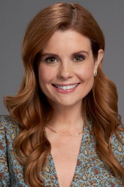 Joanna Garcia Swisher wallpapers shows a woman with long wavy hair and a floral top smiling warmly, 2K Mobile Wallpaper
