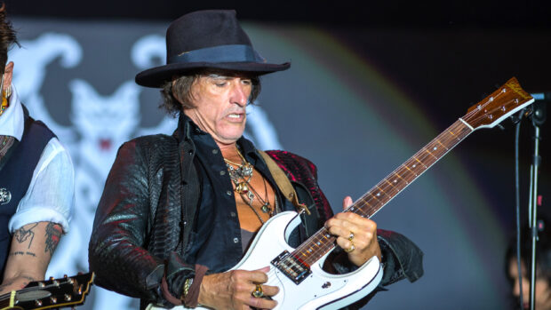 Joe Perry passionately playing the electric guitar on stage during a live performance, 2K Desktop Wallpaper