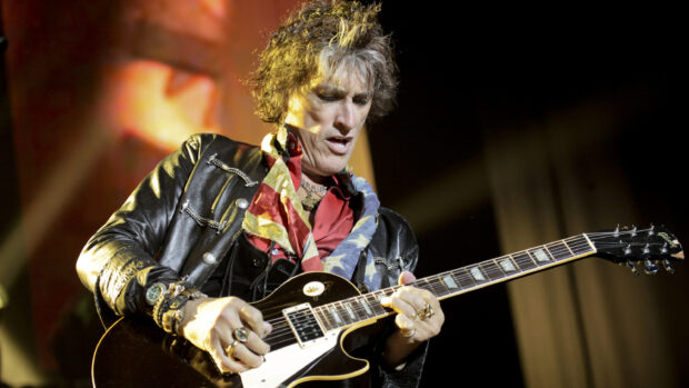 Joe Perry is passionately playing an electric guitar during a live concert, 2K Desktop Wallpaper