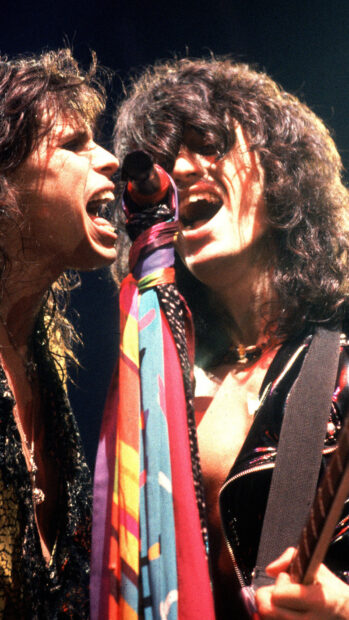 Joe Perry sings and plays guitar on stage during a concert, HD Phone Wallpaper