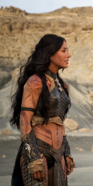 A warrior in detailed tribal armor from John Carter stands in a desert landscape, HD Mobile Wallpaper
