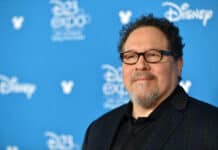Jon Favreau Wallpapers shows a man wearing glasses and a dark jacket at a Disney event, HD Desktop Wallpaper