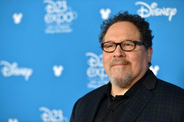 Jon Favreau Wallpapers shows a man wearing glasses and a dark jacket at a Disney event, HD Desktop Wallpaper
