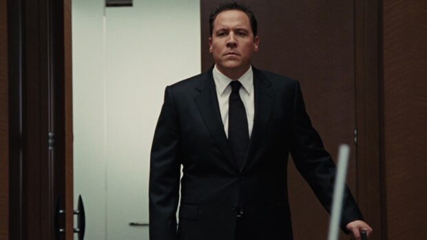 Jon Favreau stands in a suit with a serious expression in a room, HD Desktop Wallpaper