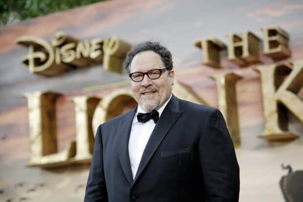 Jon Favreau is smiling and wearing a black suit at a Disney event, HD Desktop Wallpaper