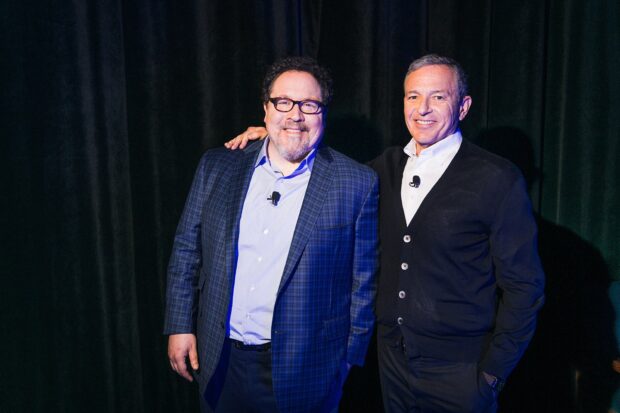 Jon Favreau stands next to a smiling man wearing a dark cardigan, HD Desktop Wallpaper