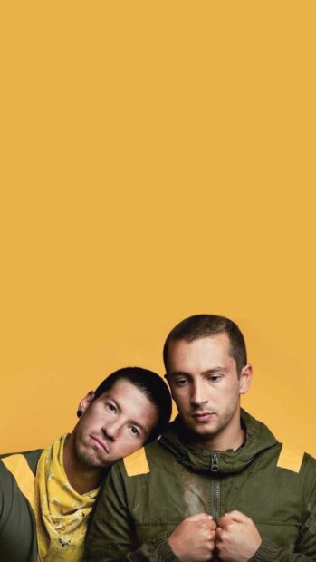 Josh Dun and Tyler Joseph wear yellow and green outfits on a solid yellow background in this Josh Dun Wallpapers, 2K Mobile Wallpaper