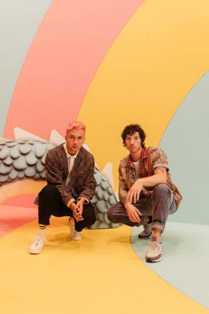 Josh Dun and another person posing in front of pastel curved shapes, 2K Mobile Wallpaper