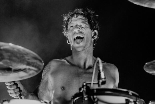 Josh Dun energetic drum performance with expression during concert, HD Desktop Wallpaper