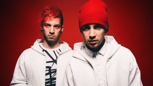 Josh Dun stands next to his bandmate against a red background while wearing white jackets, HD Desktop Wallpaper