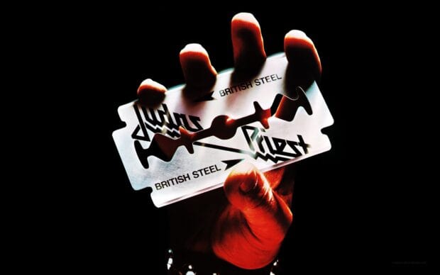 A hand holds a Judas Priest British Steel razor blade with dark background, HD Desktop Wallpaper