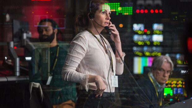 Julia Roberts is focused while talking on a headset in a newsroom filled with monitors, 4K Desktop Wallpaper