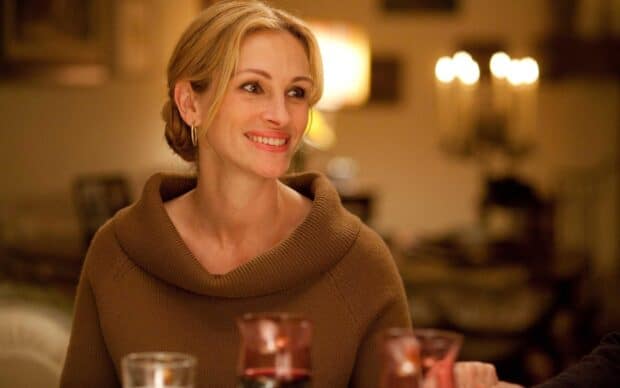Julia Roberts is smiling warmly wearing a brown sweater in a cozy indoor setting, HD Desktop Wallpaper
