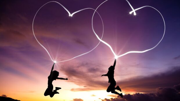 Two people jumping with glowing hearts against a colorful sunset sky with love couple wallpapers, 4K Desktop Wallpaper