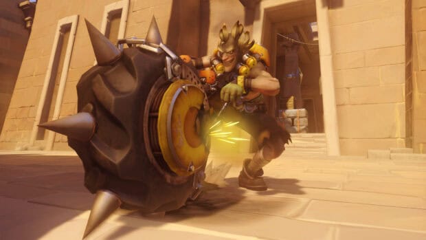 Junkrat is seen preparing to throw his explosive tire in a desert arena, HD Desktop Wallpaper