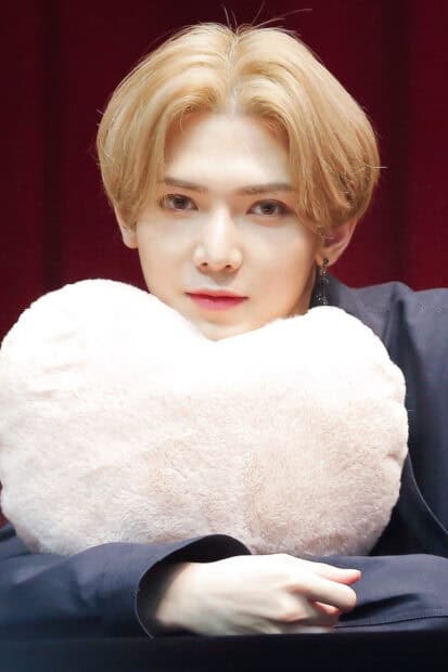 A close up image of Kang Yeo Sang holding a fluffy heart shaped pillow, HD Portrait Mobile Wallpaper