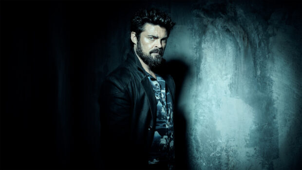 Karl Urban stands against a worn concrete wall with dramatic lighting, HD Desktop Wallpaper