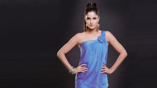 Katrina Kaif stands confidently wearing a stylish blue dress and silver accessories on a dark background, 4K Desktop Wallpaper