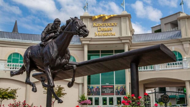 A bronze statue of a jockey riding a horse stands prominently outside the Kentucky Derby Museum, HD Desktop Wallpaper