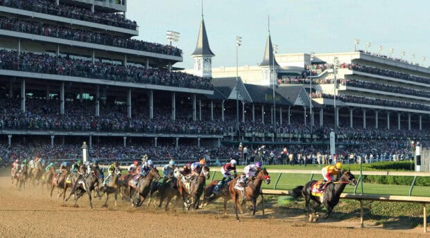 A crowded grandstand watches the intense Kentucky Derby horse race on the dirt track, 2K Desktop Wallpaper