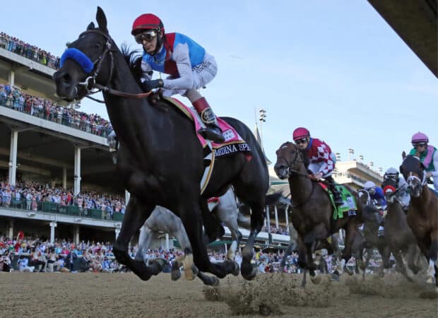 A jockey riding a horse during the Kentucky Derby race with a crowd in the background, 2K Desktop Wallpaper