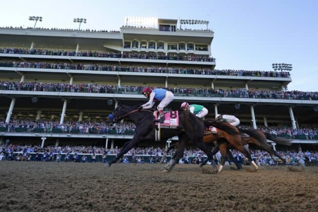 A thrilling horse race at the Kentucky Derby with a large audience in the grandstand, 2K Desktop Wallpaper