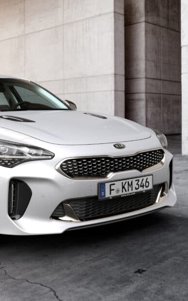 The Kia Stinger shows a distinctive front grille with bright silver accents, HD Mobile Wallpaper