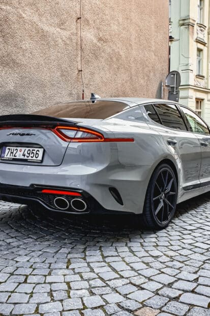 A silver Kia Stinger is parked on a cobblestone street near buildings, HD Phone Wallpaper