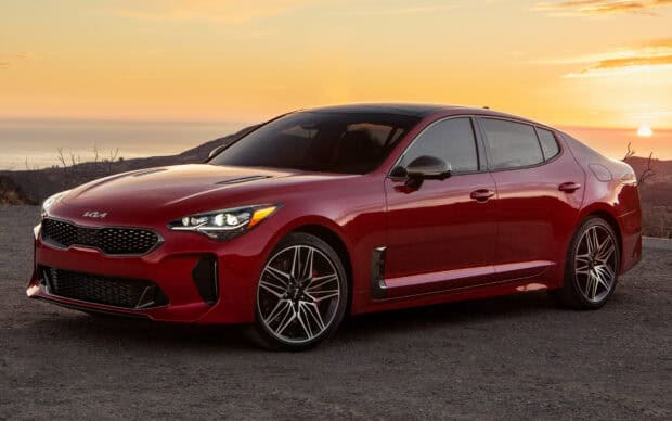A red Kia Stinger is parked on a mountain road with hills and ocean in the background, HD Desktop Wallpaper