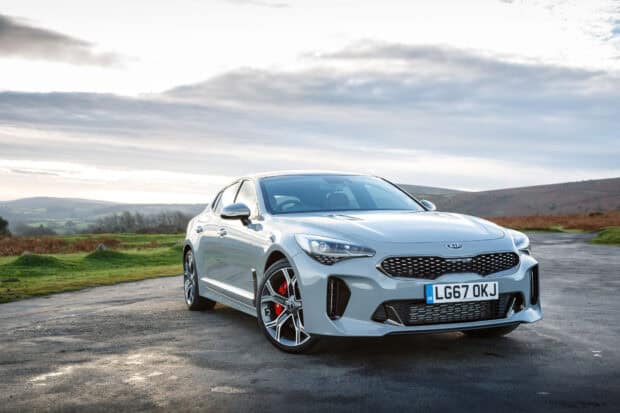 A silver Kia Stinger sports car parked on a rural road under a cloudy sky, HD Desktop Wallpaper