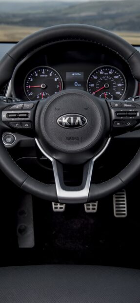 A close up of a Kia steering wheel with dashboard display and controls in view, 2K Phone Wallpaper