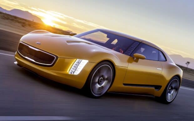 A yellow Kia speeding on a highway during sunset with a clear sky showing Kia Wallpapers 4K and Full HD, HD Desktop Wallpaper