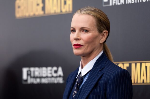 Kim Basinger wears a dark suit with a tie and bright red lipstick at a film event, 2K Desktop Wallpaper
