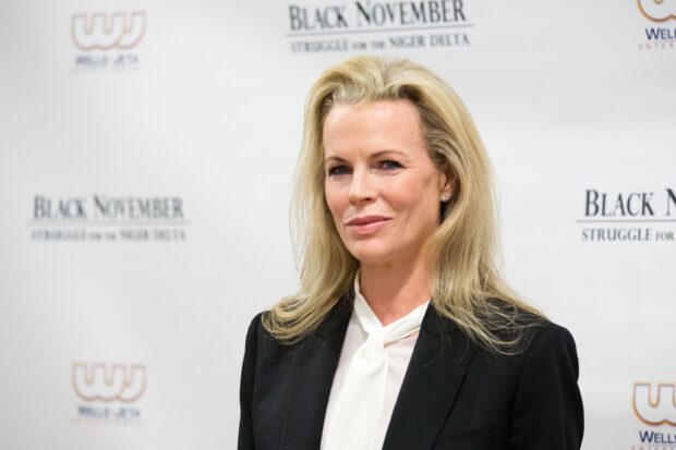 Kim Basinger smiles confidently at a film event with a white scarf and black blazer, 2K Desktop Wallpaper