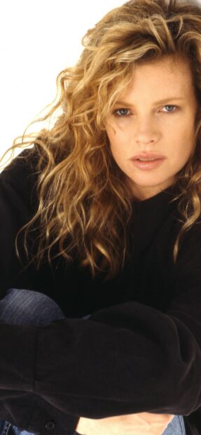 A close up portrait of Kim Basinger showing her curly hair and natural expression, 2K Mobile Wallpaper