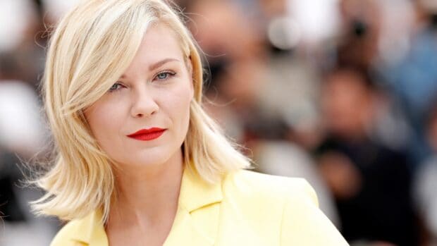 Kirsten Dunst is wearing a yellow blazer with red lipstick at a public event, 2K Desktop Wallpaper