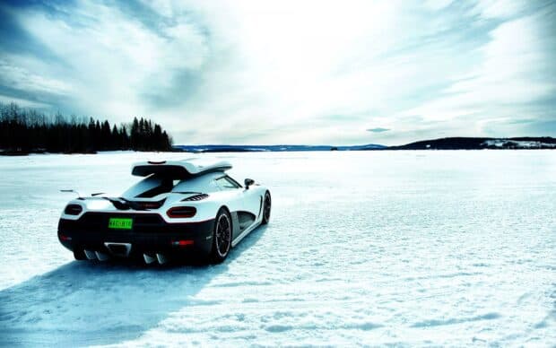 A Koenigsegg car is parked on a snowy field under a cloudy sky, HD Desktop Wallpaper