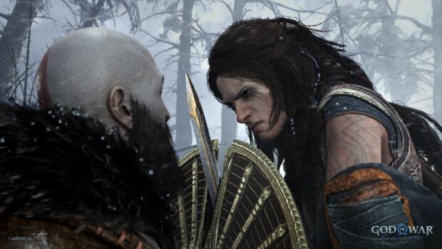 A tense confrontation between Kratos and Freya with weapons drawn in a snowy forest, HD Desktop Wallpaper