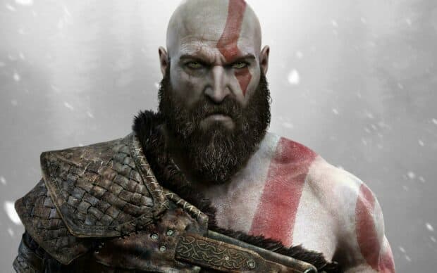 Kratos stands with war paint and armor in a snowy environment, 2K Desktop Wallpaper