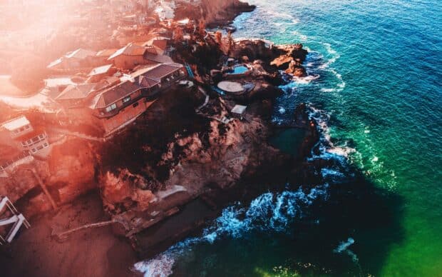 A stunning aerial view of Laguna Beach coastline with clear blue water and rocky cliffs, 2K Desktop Wallpaper