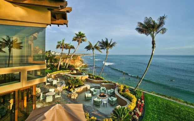 A scenic view of Laguna Beach with palm trees and ocean waves, HD Desktop Wallpaper