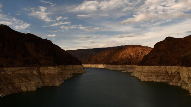 The calm waters of Lake Mead stretch between rocky mountains under a cloudy sky, HD Desktop Wallpaper