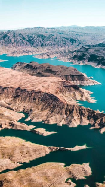 The image shows Lake Mead surrounded by desert mountains and clear blue water, HD Phone Wallpaper