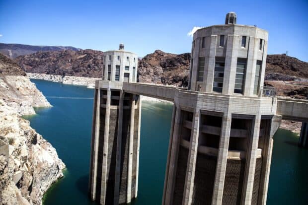 The Lake Mead features water towers and a large reservoir surrounded by rocky hills, HD Desktop Wallpaper