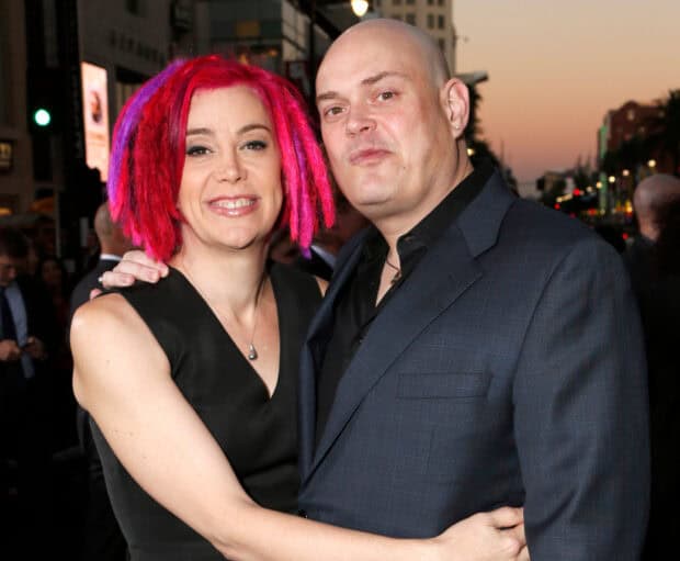 Lana Wachowski is hugging a man in a suit at an outdoor event during sunset, HD Desktop Wallpaper